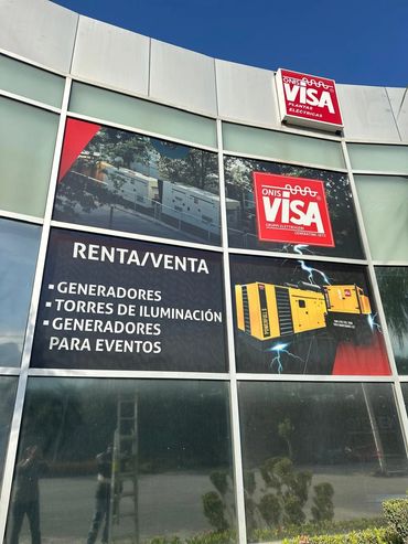 Microperforado publicitario instalado en ventanales de ONIS VISA, con gráficos de generadores.