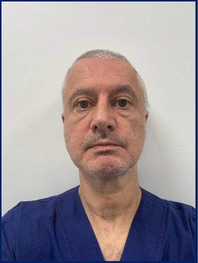 Middle-aged man in blue medical scrubs against white background.