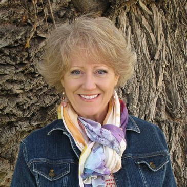 A woman smiling headshot wearing denim jacket