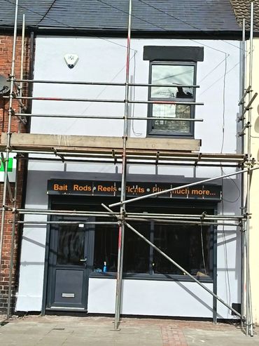 A fishing supply shop under renovation with scaffolding outside.