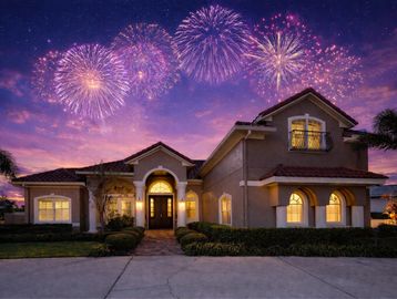 Fireworks light up the sky above a cozy suburban house at dusk.