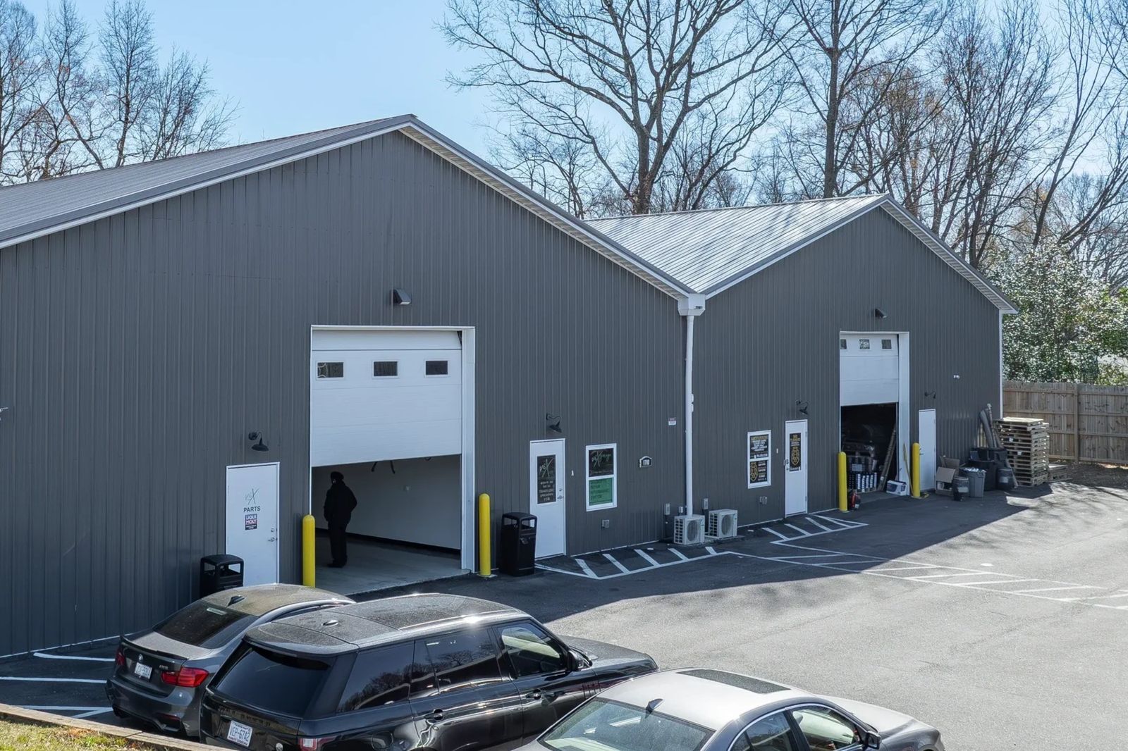 Industrial building with parking spaces and parked cars.