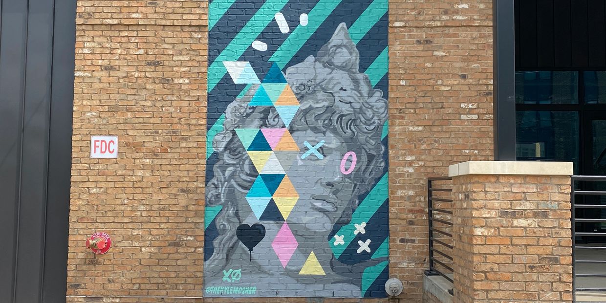 A grey classically-styled portrait against blue and green striped background. with traingle shapes.