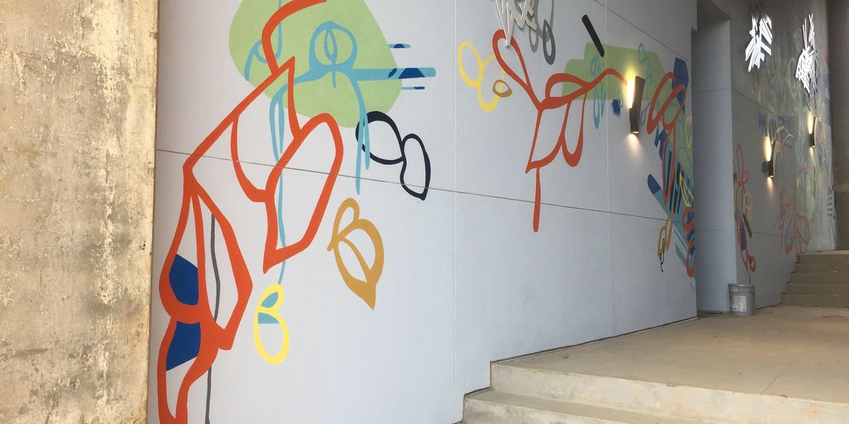 Abstract mural with orange lines, green shapes, and other small designs.