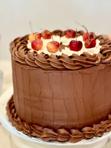 Chocolate cake with whipped cream and cherries