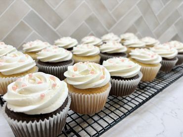 Chocolate and vanilla cupcakes with white buttercream and pink sprinkles
