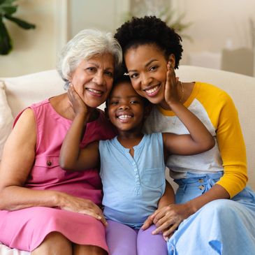 Three generations of family members - grandmother, mother and daughter - all smiling.