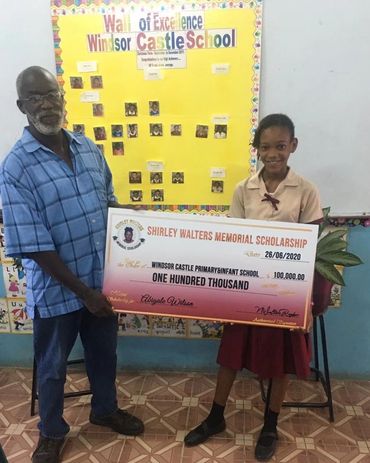 scholarship recipient  stand with  grand father holding giant cheque received from Shirley Walters M
