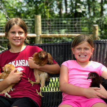 happy girls holding chickens
