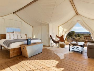 Spacious luxury glamping tent with wooden floors and desert views.