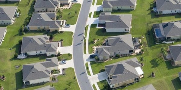 Aerial view of a suburban neighborhood with houses and green lawns.