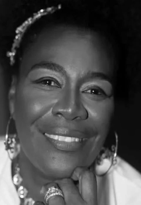 Stack of books next to pencils in a holder and a camera.