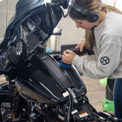 Jasmine buffing scratches out of the tank on a black Harley Davidson Street Glide