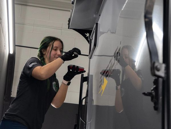Jasmine installing ceramic coating on an enclosed trailer to increase gloss & make maintenance easy