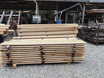 Stacks of wooden planks organized in an outdoor lumber yard.