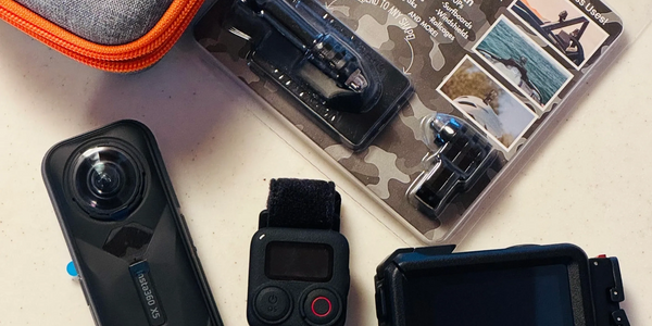 A set of action cameras and accessories arranged on a surface.