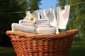 Whicker basket with fresh cleaned towels and a flower on top