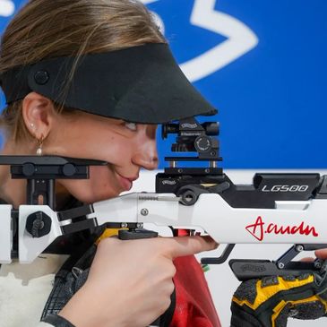 A focused shooter aiming with a precision rifle at a competition.