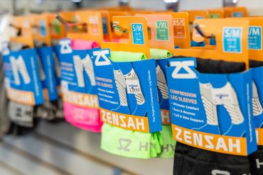 Rows of colorful compression leg sleeves on display.