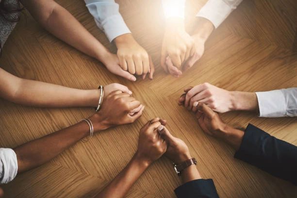 group holding hands in support of one another