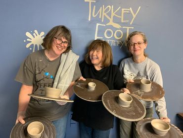 girls with their wheel-thrown pottery results beginners