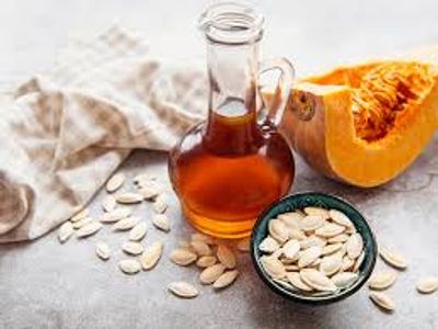 Jug of Organic Pumpkin seed oil a pumpkin and pumpkin seeds displayed