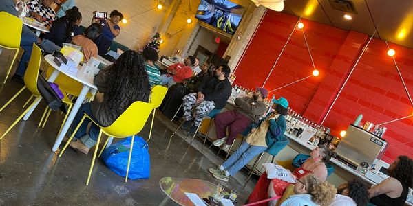People gathered in a cozy café setting, engaging in activities and conversations.