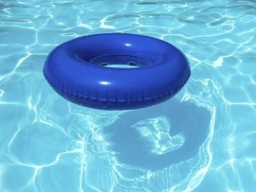 A blue inflatable ring floating in a clear swimming pool.