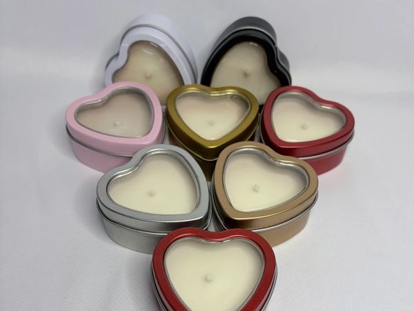 Heart-shaped candles in various colored tins.