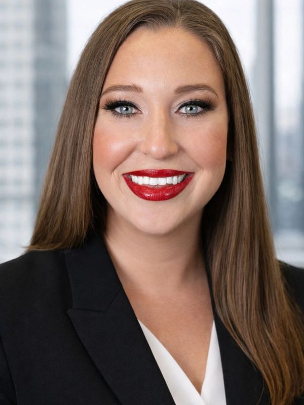 Professional woman with long brown hair and red lipstick smiling.