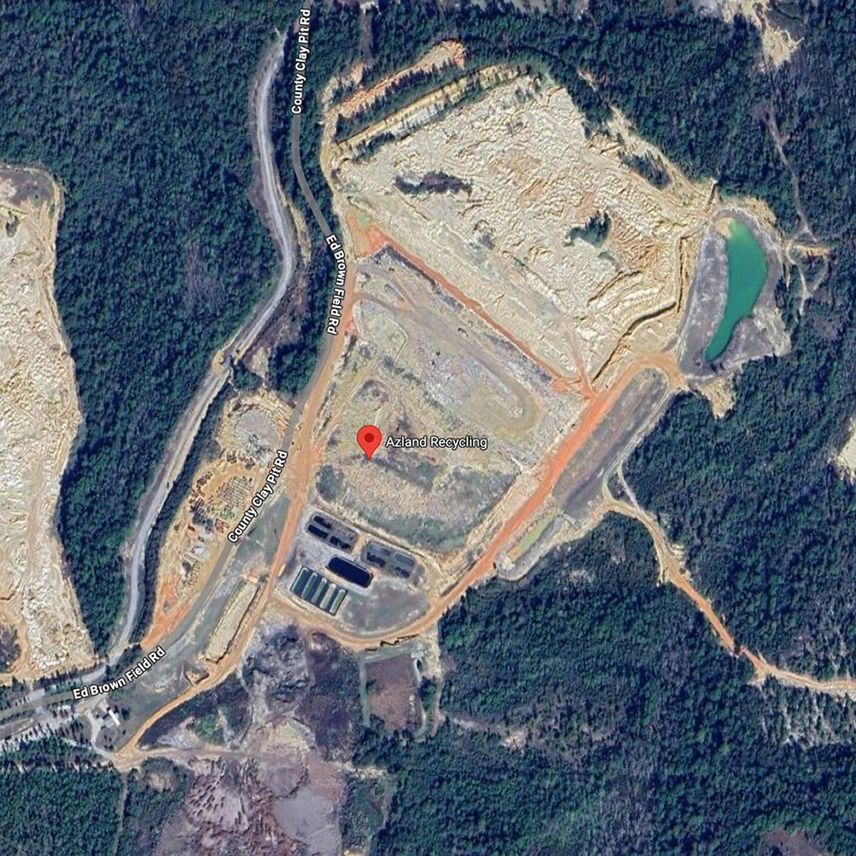 Aerial view of Azland Recycling surrounded by dirt roads and forest.