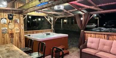 Step out into the luxurious hot tub situated under a rustic pavillion. 