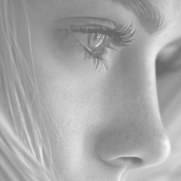 Close-up of a woman's contemplative eye and nose in black and white.