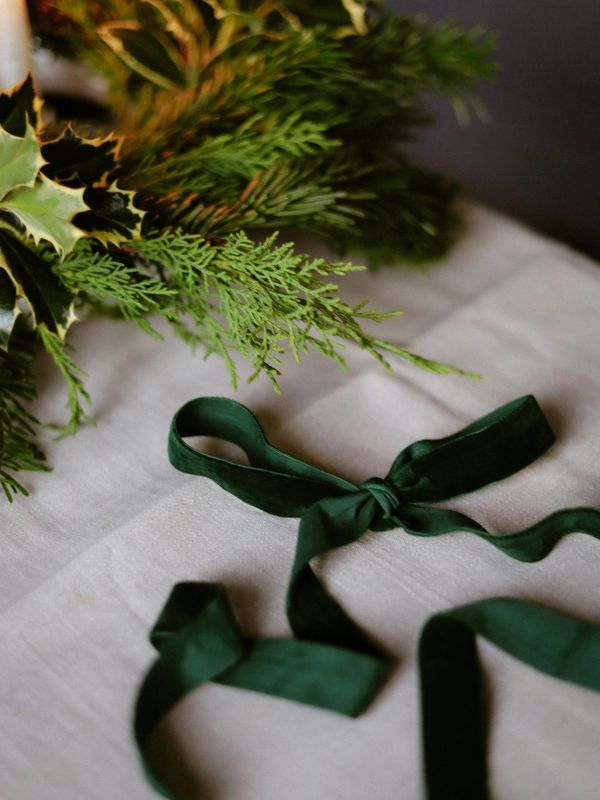 Green wreath and ribbon on a soft cloth. Christmas Decor