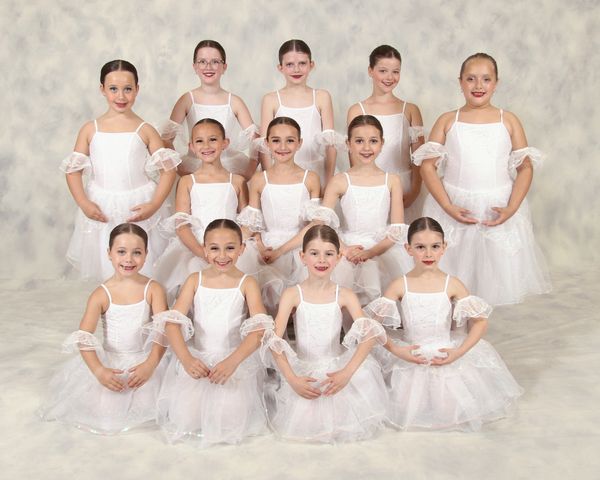Group of young ballerinas in white tutus.