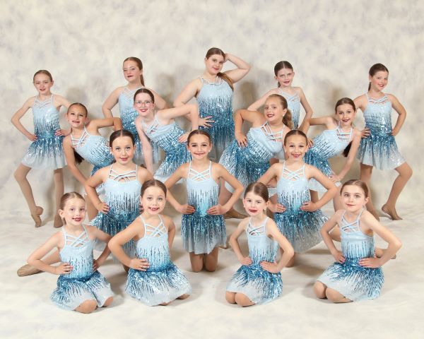 Group of young dancers in blue and white costumes posing.