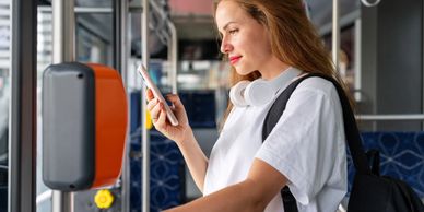 Woman using phone while waiting for transit.