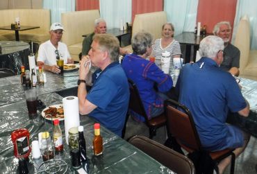 A group of older adults dining together in a casual restaurant setting.