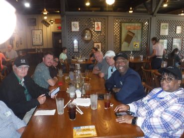 A group of people seated around a wooden table in a restaurant.