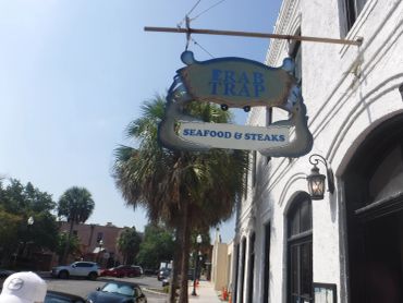 Crab Trap seafood and steak restaurant sign on a sunny street.
