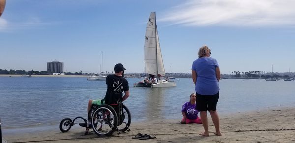 Austin and Paige hanging out on the beach while the Reynolds sails in the background.