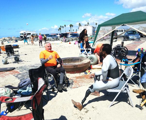 Image of Albert and Ty sitting around base camp and talking after a surf session.