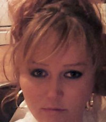 Close-up of a woman with blonde hair and hoop earrings.