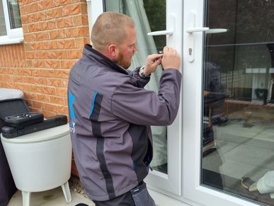 a locksmith repairing a door lock.