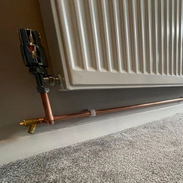 A radiator with copper pipes underneath