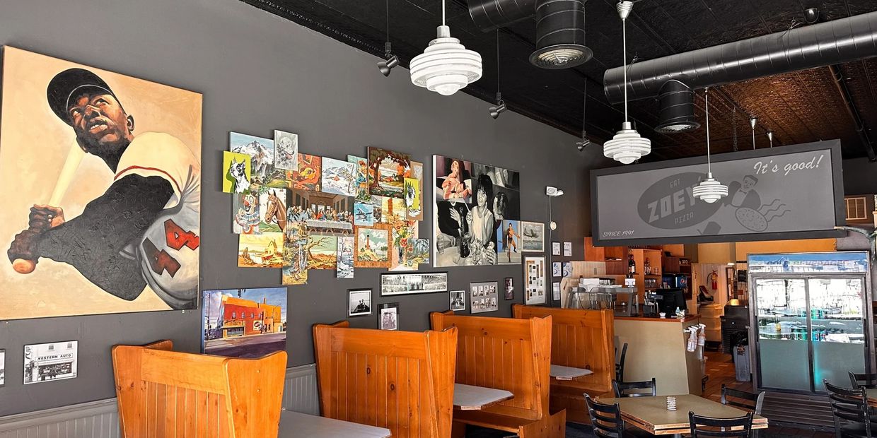 Cozy pizza restaurant with wooden booths and eclectic wall art.