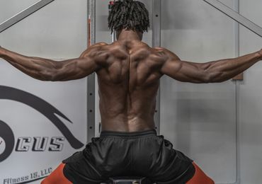 A fit individual demonstrates a workout using gym equipment, with weights and various machines