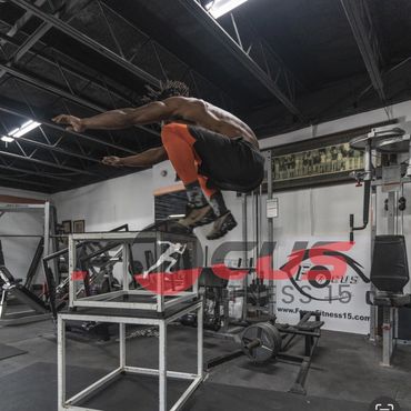 A person performing an exercise in a gym,using equipment for strength training.