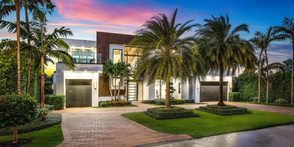 Modern house with palm trees at sunset.