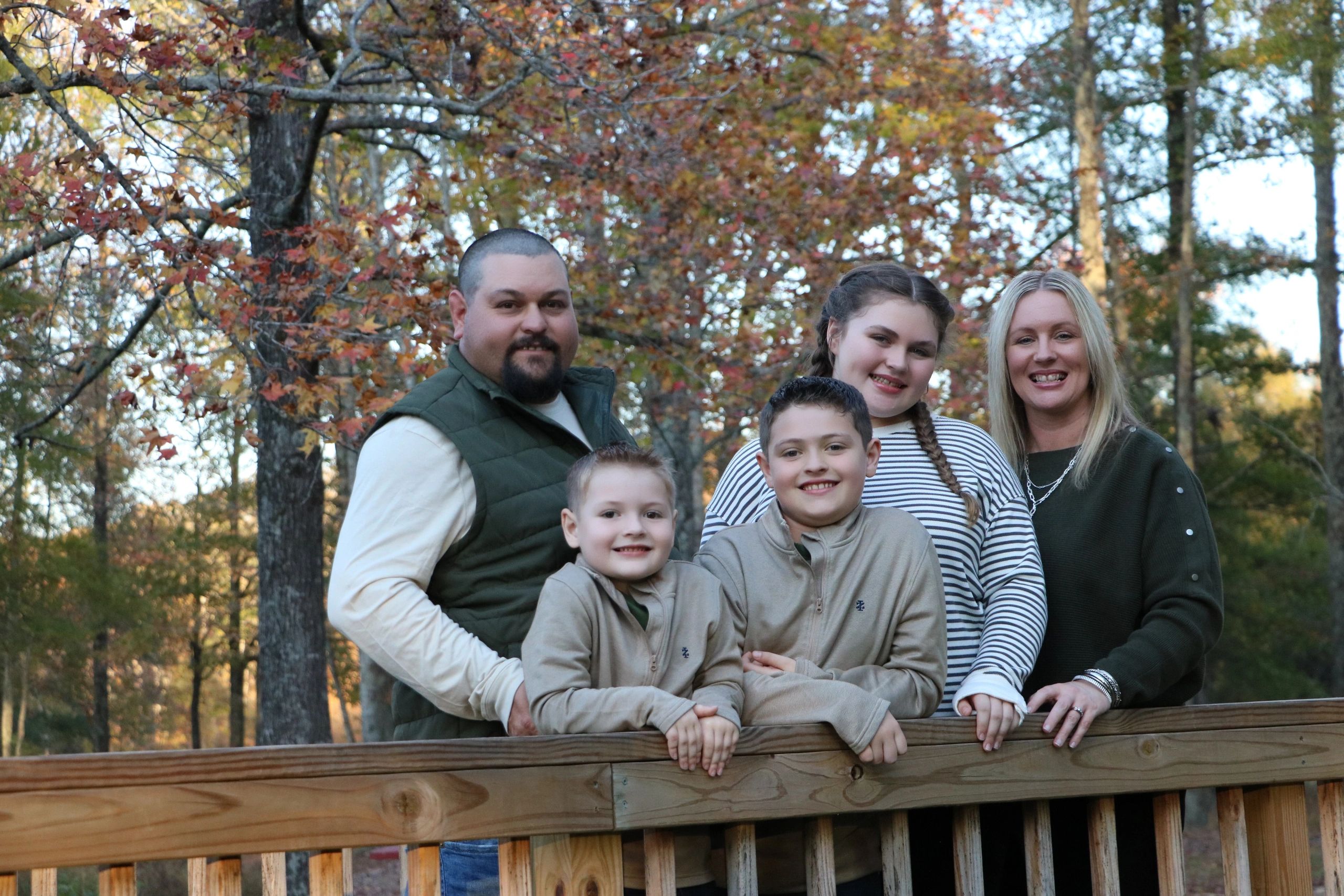 Stack of magazines next to a pencil holder with black pencils and a blurred camera in the background.